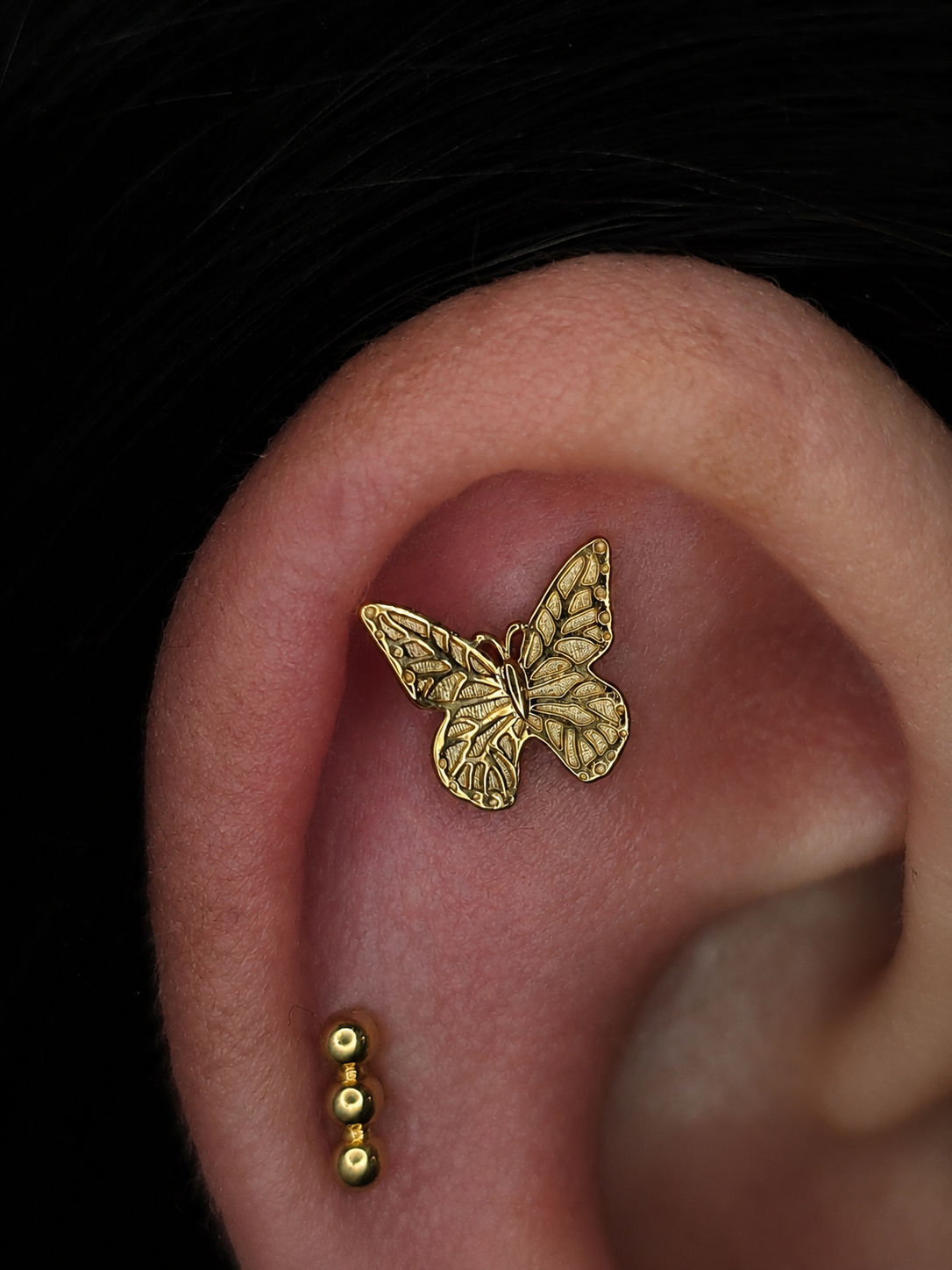 Detailreicher Schmetterling Piercing Aufsatz aus massivem 14 Karat Gelbgold mit filigraner Flügelstruktur und Pin Stecksystem für verschiedene Ohrpiercings wie hier im Helix