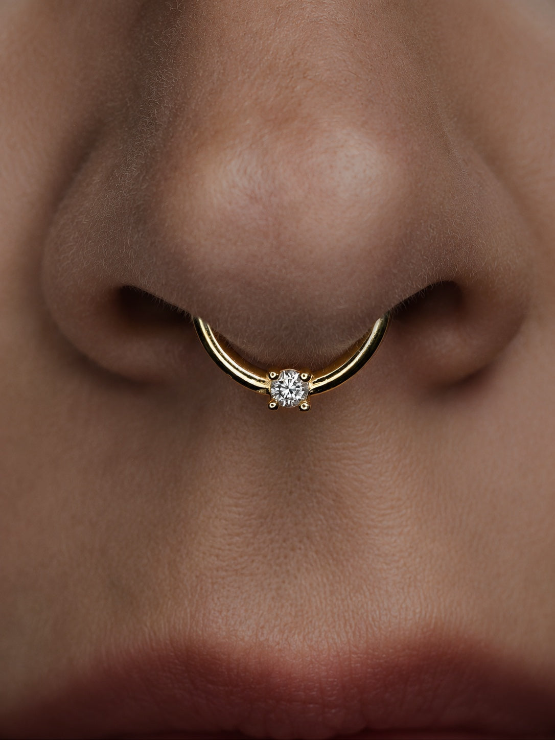 Clicker in soliden Echtgold mit einem hochwertigen Echtdiamant passend für Septumpiercings und viele Piercings am Ohr hier frontal im Septum getragen